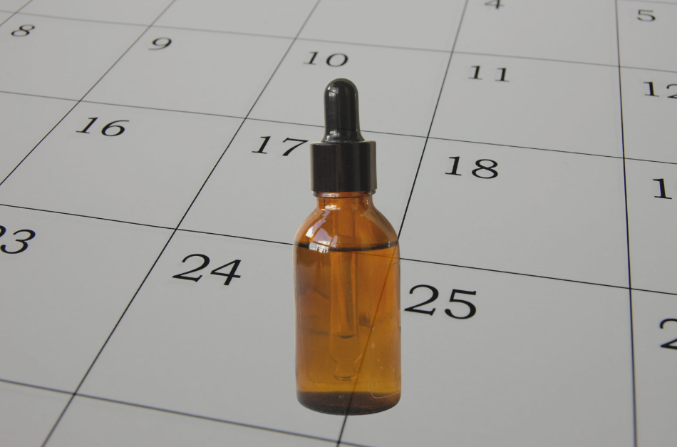 Bottle of oil with a calendar behind it to resemble the shelf life of a product