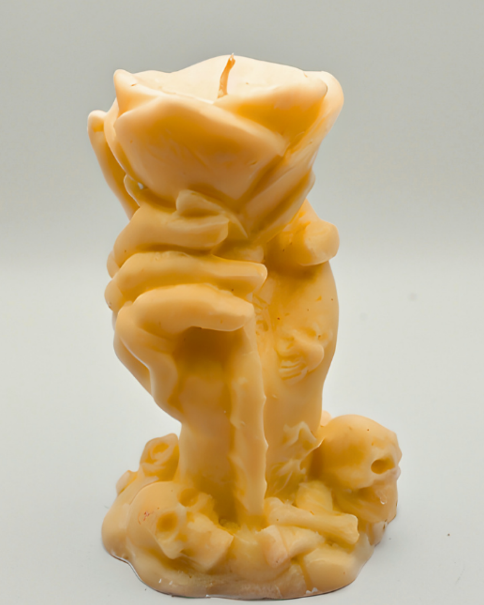 Amber orange hand & Rose Candle on a light gray background