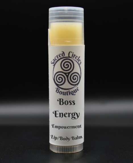Lip balm tube labeled 'Boss Energy' from Sacred Circles Boutique on a black background
