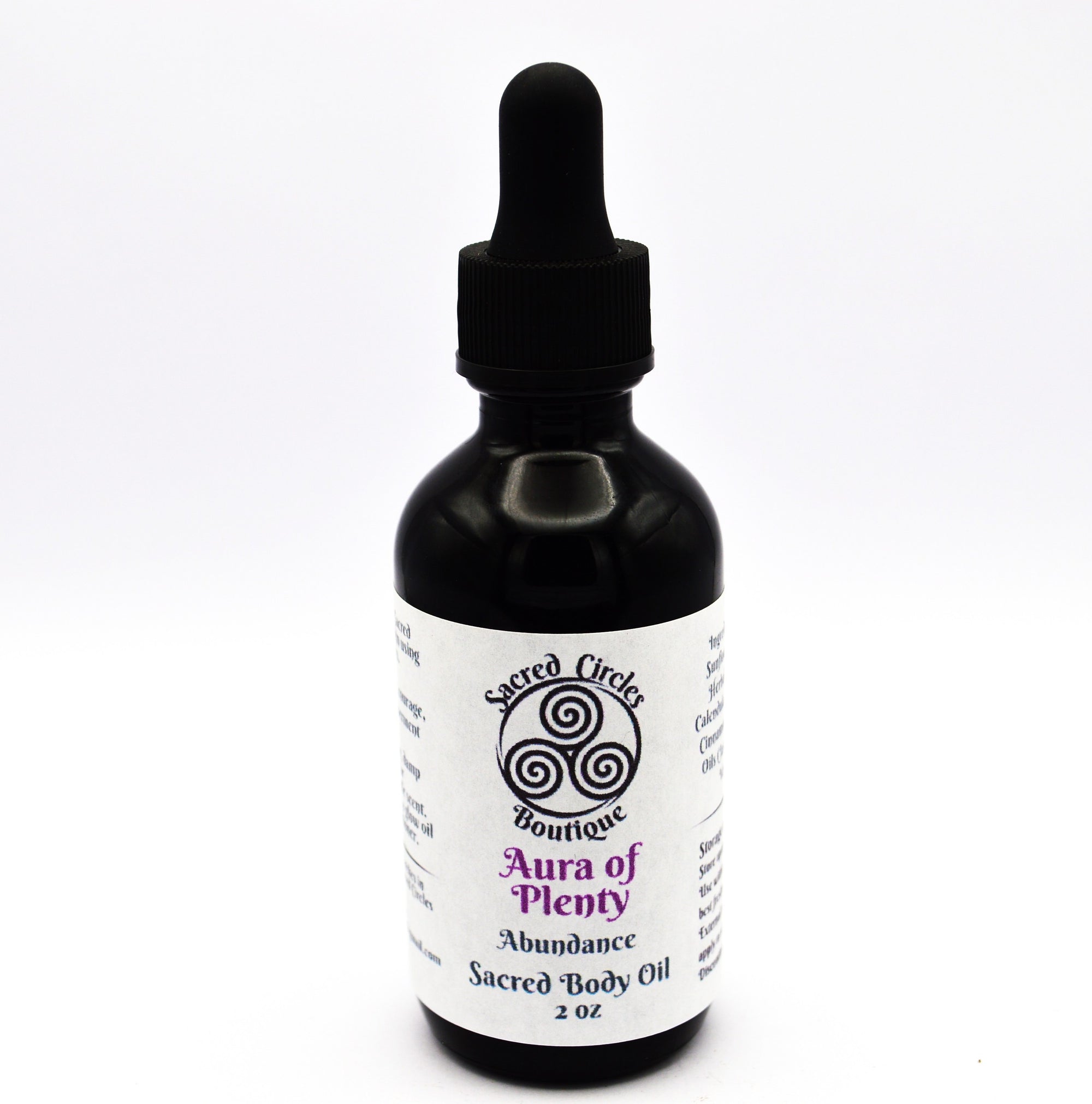 Bottle of 'Aura of Plenty' sacred body oil with a dropper on a white background