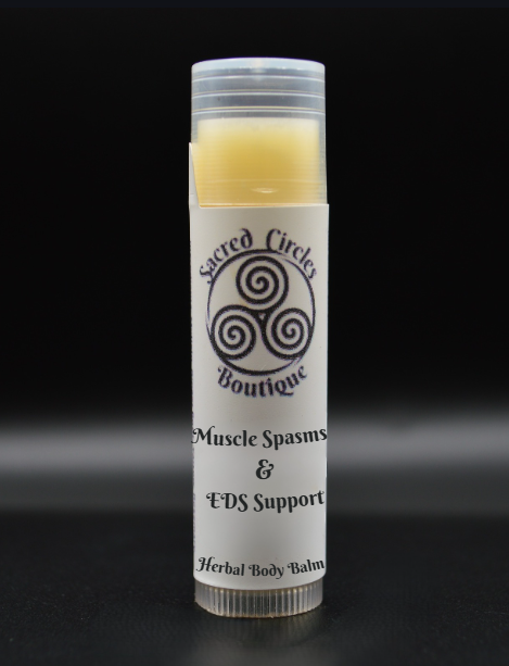 Balm tube labeled 'Muscle Spasms & EDS Support' with 'Sacred Circle Boutique' logo on a black background