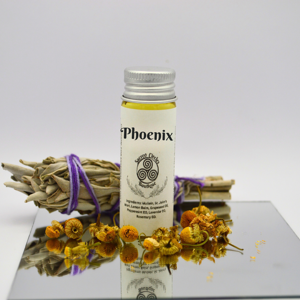 Phoenix body oil in 15 mL with dried herbs and flowers on a reflective surface